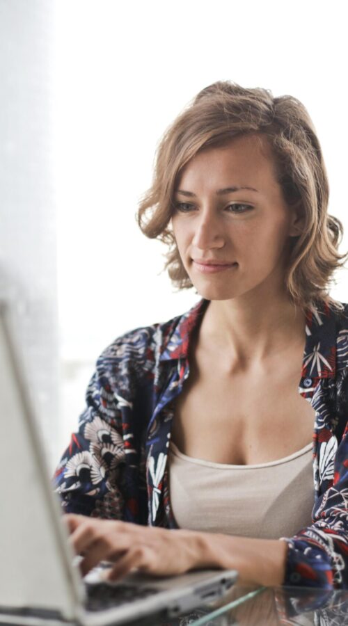 pexels-photo-806835-806835 | Freedom For You 2 A woman typing on a laptop in a bright, modern home office setting.