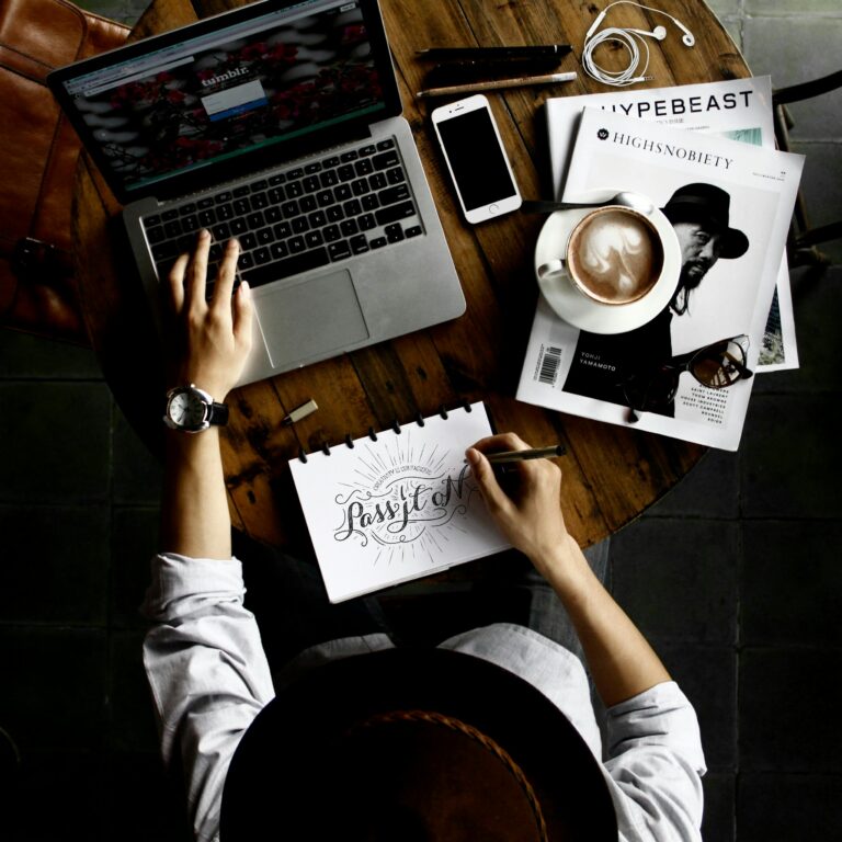how can I start an online business | Freedom For You 2 Top view of a creative workspace with laptop, coffee, and hand lettering for design inspiration.