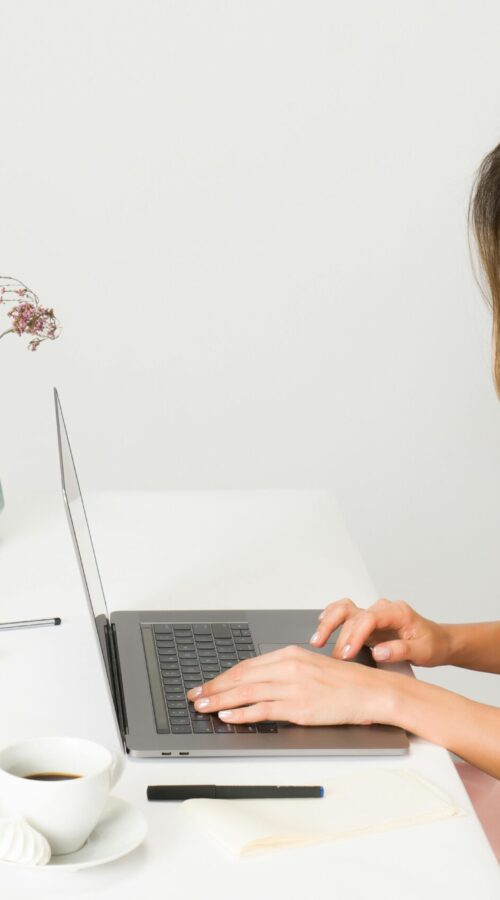 pexels-photo-1586973-1586973 | Freedom For You 2 A woman in a pink dress working on a laptop at a modern, minimalist desk.